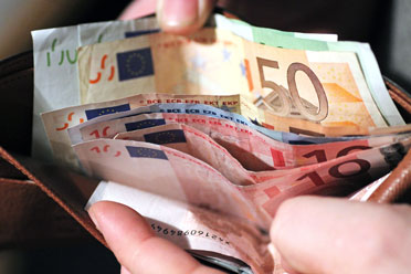 18-minijob-arbeitslos1  Person zählt bunte Euroscheine in einem braunen Portemonnaie.